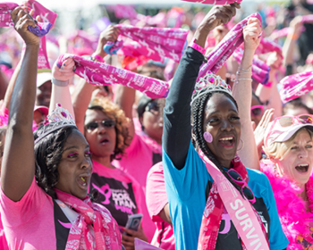 women in pink cheering in a crowd